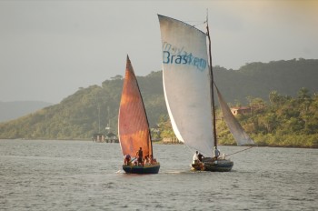 A gaff-rigged saveiro overhauls a little lug-sailed peneiro