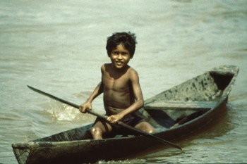 A small boy on the Amazon paddling a small dug-out